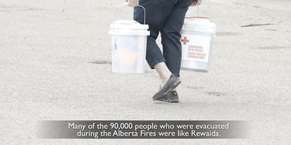 A woman carries a Canadian Red Cross clean-up kit