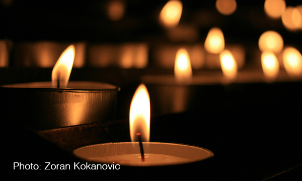 Tealight candles burn in darkness.