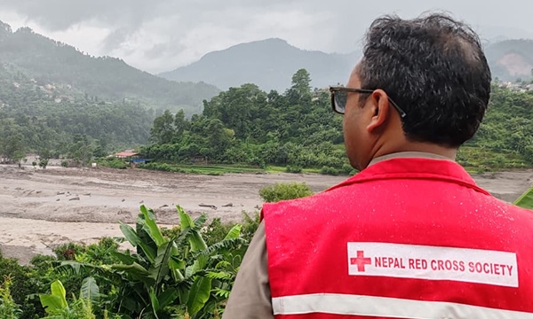 A Nepal Red Cross Society responder looks over a flood-affected area in Nepal.