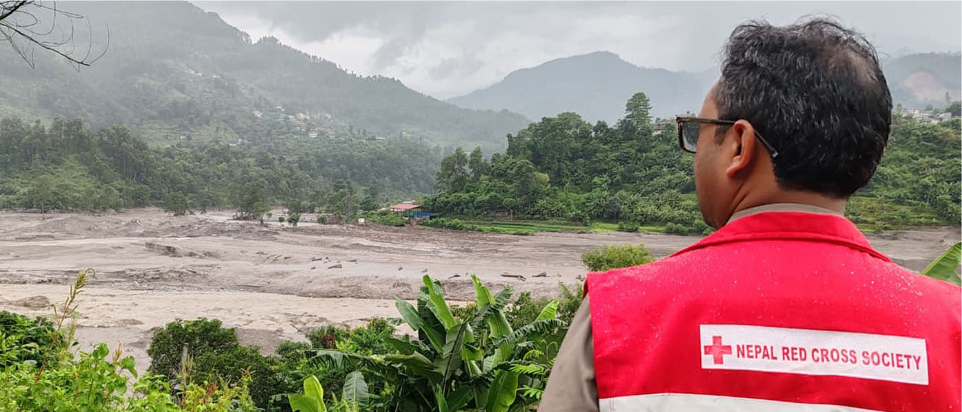 Un membre du personnel humanitaire de la Croix-Rouge du Népal constate l’étendue des dégâts causés par les inondations au Népal.
