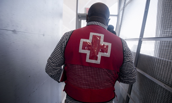 A person with a Canadian Red Cross vest facing away from the camera. 