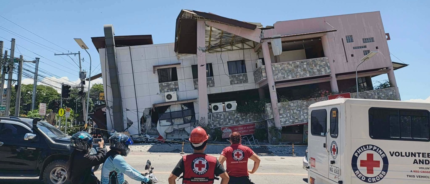Members of the Philippine Red Cross observe a damaged building.