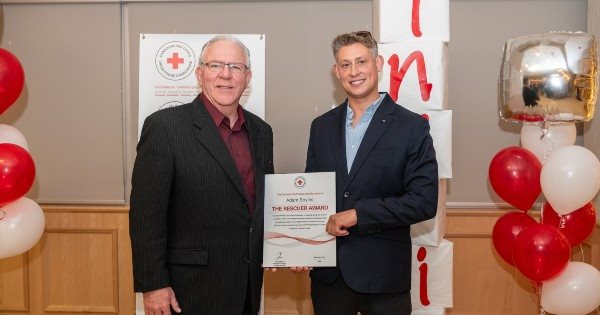 Adam Boyles holding his rescuer award