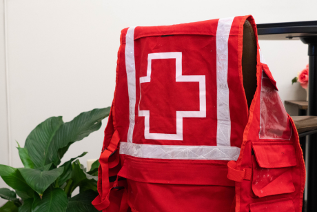 A red Canadian Red Cross vest with the Red Cross emblem resting on the back of a chair