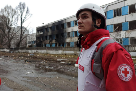 A member of the Ukrainian Red Cross stands before a damaged maternity hospital in Dnipro, Ukraine.