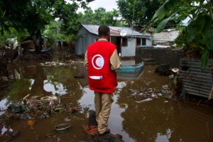 A member of the Comoros Red Crescent standing back on in a flooded community in Comoros.