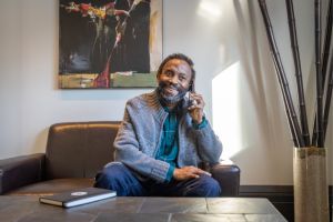 A Friendly Calls volunteer smiles while speaking on the phone.