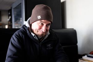 Daryl Huculak smiling, sitting in a booth at his Bistro.