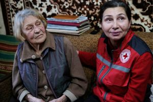 Nadiia Zmurko and Olena Sykotyuk sit on a couch in a living room.