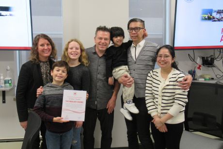 Christian Clavelle standing with the family of the child he saved.