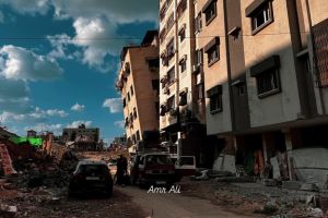 A street with two vehicles in front of buildings in Gaza City.