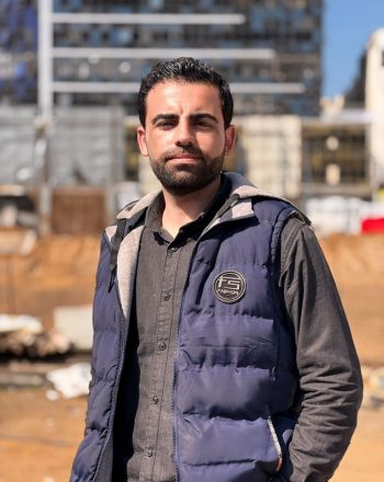 A headshot of Amr, standing in front of a building.