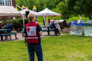 Canadian Red Cross personnel wearing a Red Cross vest at a community event in a park.