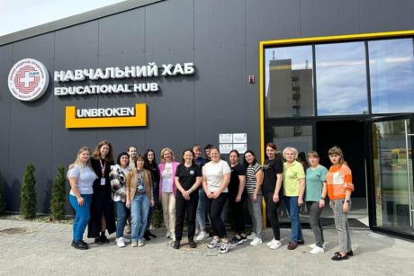 Lynn Henderson and a group of nurses who received training stand in front the educational hub in Lviv for a group photo.