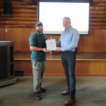 Bradley Bator holding a Red Cross Rescue Award certificate for life-saving at Riding Mountain National Park.