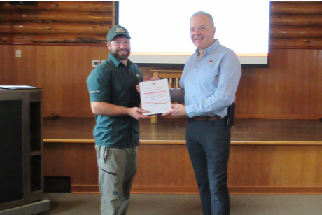 Bradley Bator holding a Red Cross Rescue Award certificate for life-saving at Riding Mountain National Park.