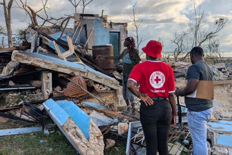 Jamaica Red Cross personnel stand in front of debris and damage from Hurricane Melissa.