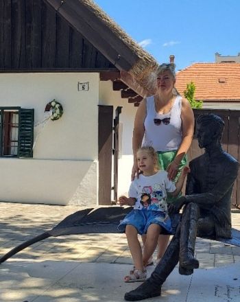 Lana and Anastasia pose for a photo with a statue.