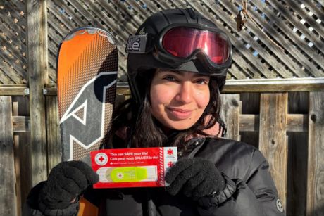 Une personne tenant une pochette médicales d’urgence de la Croix-Rouge
