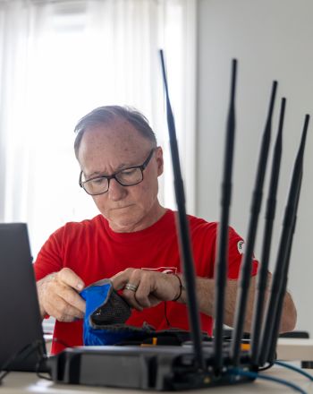 James Spooner working at a desk with various tech equipment.