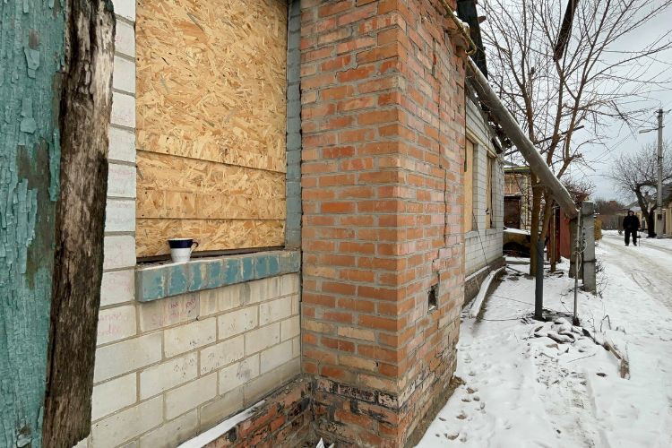 A building with windows boarded following an attack.