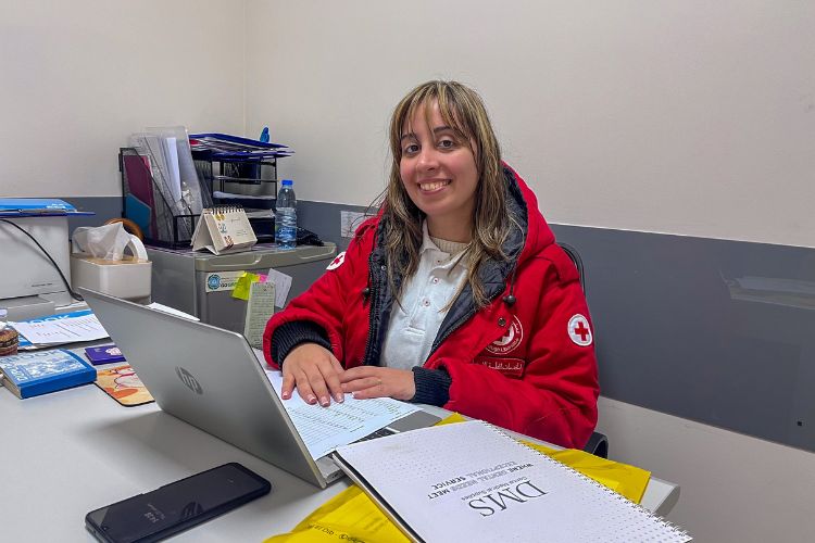 Marie-Helene El Asmar sits behind a desk on a computer.