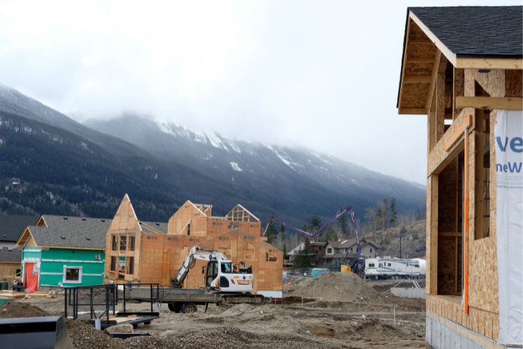 Photo de maisons en construction avec un paysage montagneux en arrière-plan.