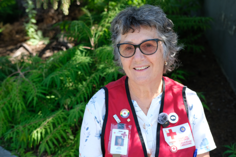 Canadian Red Cross volunteer, Janis Brown, pictured outdoors wearing a red vest.