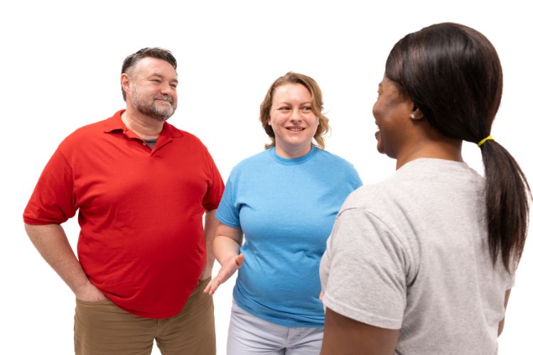 Three happy people smiling and talking about the benefits of exercise for physical and mental health.