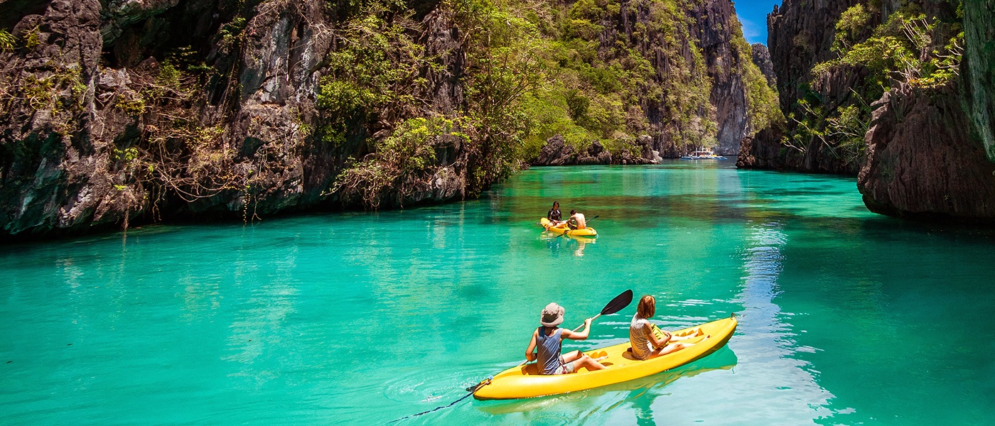 Deux personnes rament ensemble dans un bateau, dans un cadre pittoresque et magnifique, entourées par la nature.
