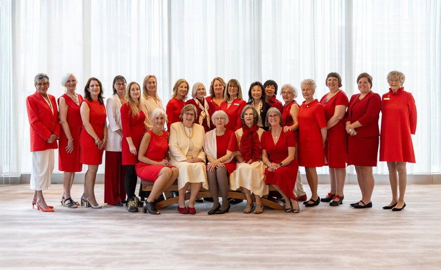Tiffany Circle Members pose for a photo, all wearing red and smiling together.