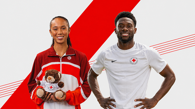 Alphonso Davies et Leylah Fernandez se tiennent côte à côte : à gauche, Leylah tient un ourson de la Croix-Rouge ; à droite, Alphonso porte un t-shirt de la Croix-Rouge. 