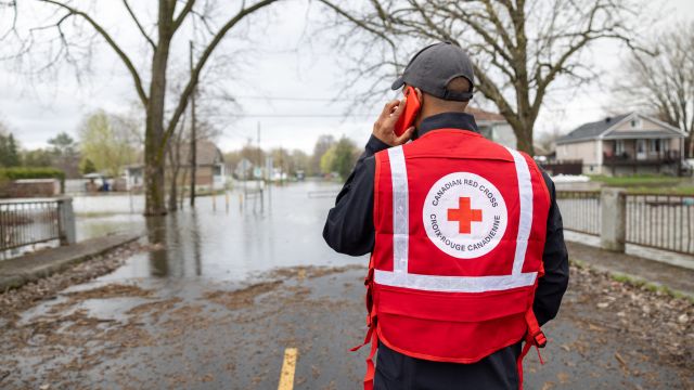 Le personnel de la Croix-Rouge debout dans une rue inondée.