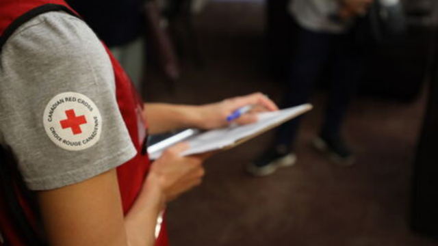 Un membre du personnel de la Croix-Rouge canadienne tenant un bloc-notes et un stylo