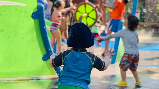 Children playing at a splash pad at a water park. 