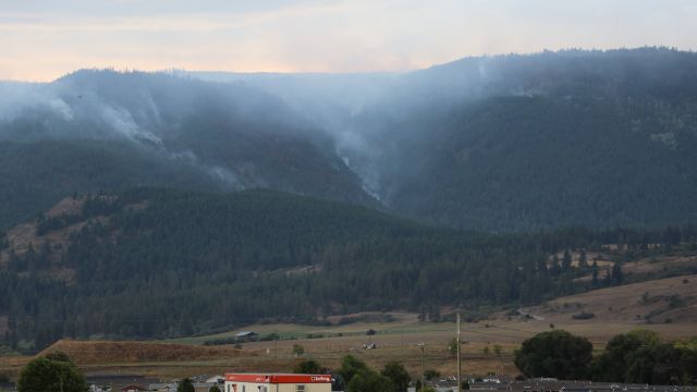 Fumée d'un feu de forêt dans une région montagneuse.