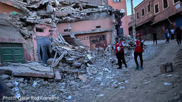 Members of the Moroccan Red Crescent next to a house destroyed by the earthquake
