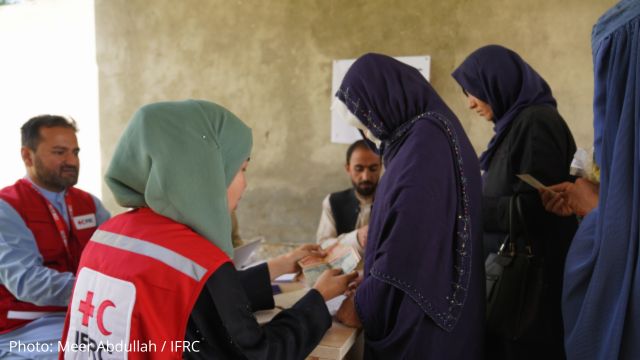 IFRC volunteer helping a group of women in Afghanistan