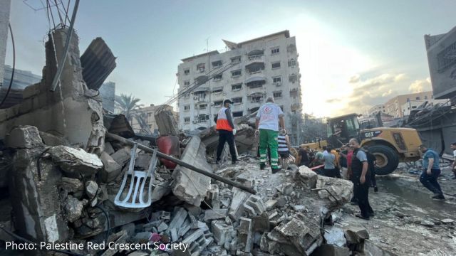 A group of people standing on a pile of rubble.
