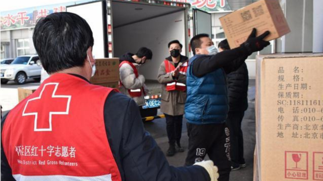 Le personnel de la Croix-Rouge décharge des boîtes d'un camion.