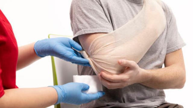 Applying a tubular sling to support an injured arm.