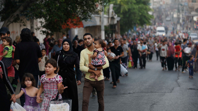 Une famille de cinq marche dans la rue, entourée de plusieurs autres personnes civiles