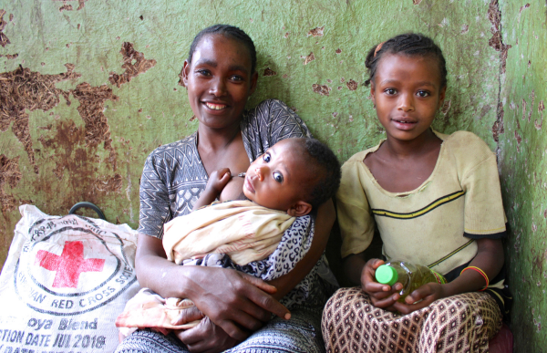 A woman who received support from the Ethiopian Red Cross Society photographed with two of her children.