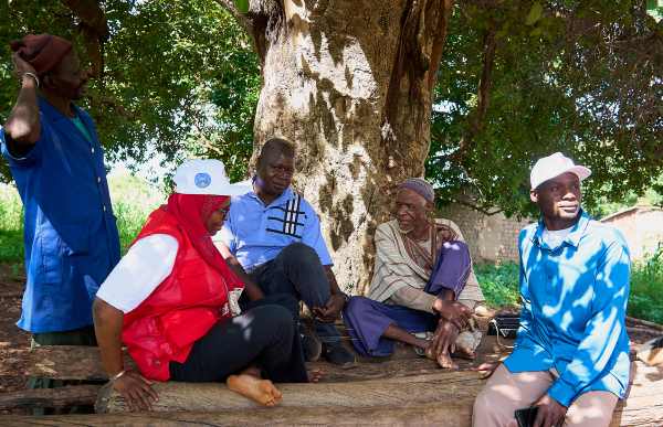Red Crosser sitting with a community recipients.