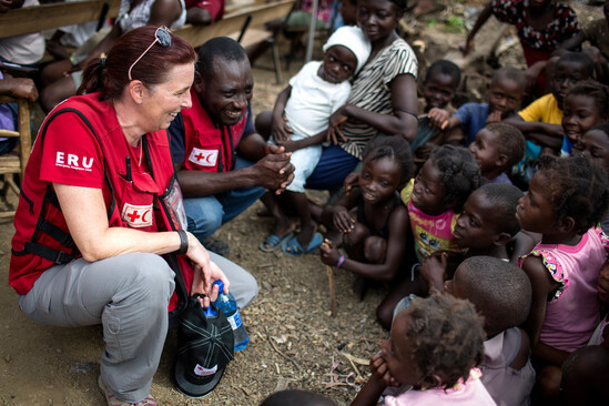 Red Cross workers playing with children after hurricane