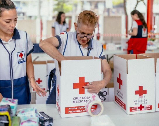 Red Cross team member packing a donation box