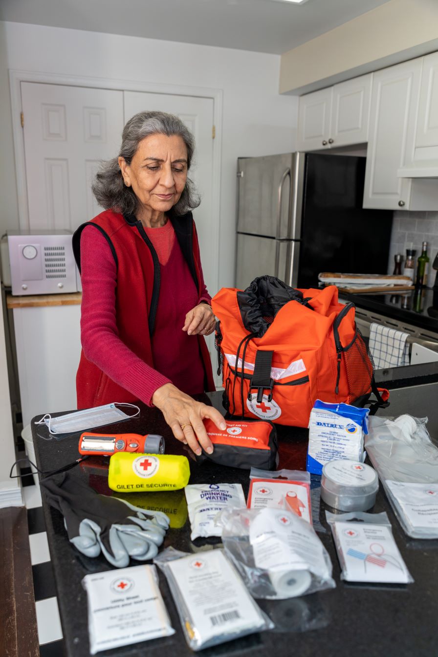 An older woman packs an emergency Grab and Go bag in her kitchen.