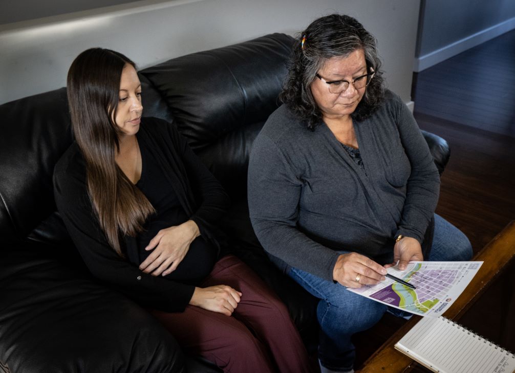 Une femme enceinte et sa mère examinent un plan d’urgence.