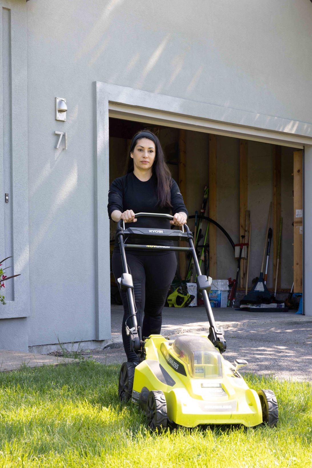 A woman mows the lawn to mitigate the risk of fire catching on tall grass. (Credit John Falcon)