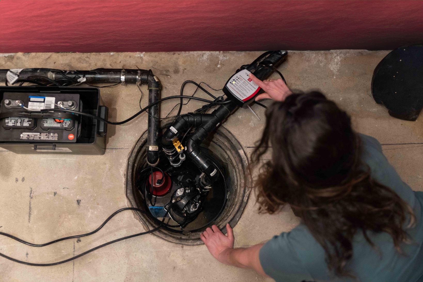 Une personne vérifie le bon fonctionnement d’une pompe de vidange au sous-sol. (Source : John Falcon)